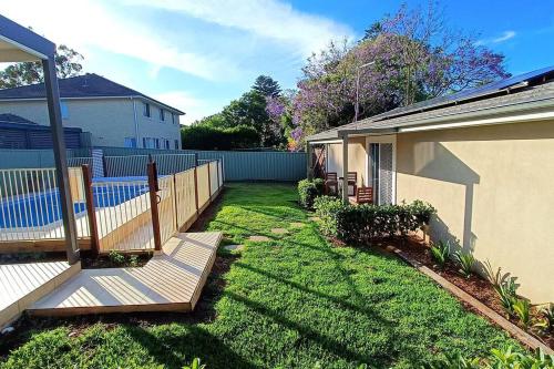 a yard with a fence and a house at New and Cozy 2 Bedrooms Granny Flat with Aircon & Pool in Baulkham Hills