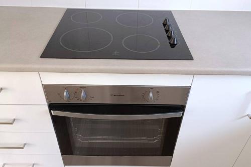 a stove top oven sitting in a kitchen at New and Cozy 2 Bedrooms Granny Flat with Aircon & Pool in Baulkham Hills