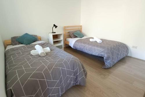 two beds sitting next to each other in a bedroom at New and Cozy 2 Bedrooms Granny Flat with Aircon & Pool in Baulkham Hills