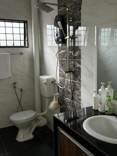 a bathroom with a shower and a toilet and a sink at Homestay Hajrah in Ipoh