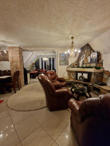 salon ze skórzanymi meblami i kominkiem w obiekcie Home Belić Golija w mieście Radaljica