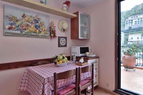 a kitchen with a table with a bowl of fruit on it at Villa Anna in Minori