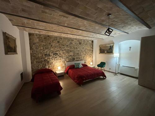 a bedroom with a red bed and a stone wall at Dream House Castellana in Castellana Sicula