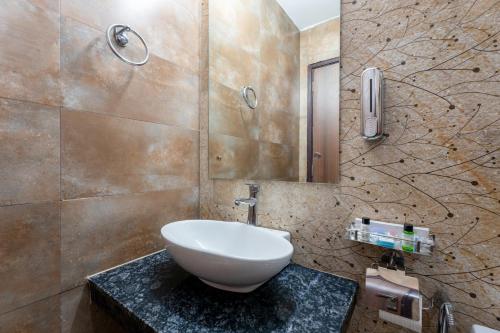 uma casa de banho com um lavatório branco num balcão em Plum Tree Hotels em Gurgaon