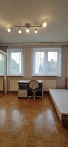 Pokój z 2 łóżkami, stołem i oknami w obiekcie Cosy Room w mieście Patan