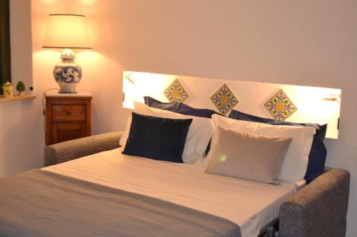 ein Schlafzimmer mit einem großen Bett mit weißen Kissen in der Unterkunft Casa Marina Taormina in Taormina