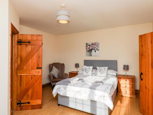 1 dormitorio con 1 cama y puerta de madera en Twyford Farm Cottage en Tiverton