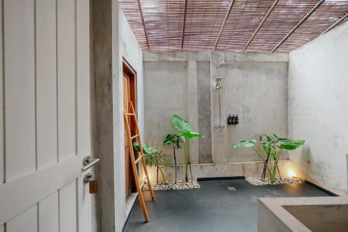 a room with potted plants in a room with a ceiling at The Room Padang-Padang in Uluwatu