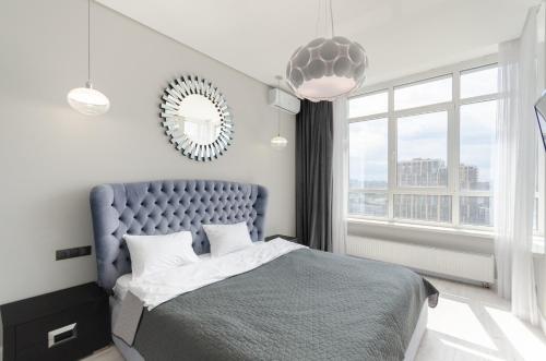 a bedroom with a blue bed and a large window at 19267 Residential complex Central Park cozy apartment in Kyiv