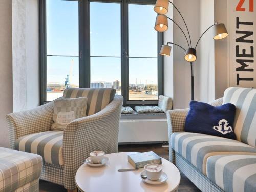 ein Wohnzimmer mit Sofas, einem Tisch und einem Fenster in der Unterkunft Ohlerich Speicher App. 21 in Wismar