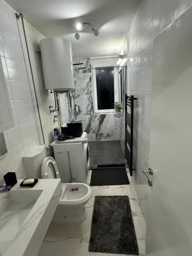 een witte badkamer met een toilet en een wastafel bij Vertu No1-Apartment in hearth of Sarajevo in Sarajevo