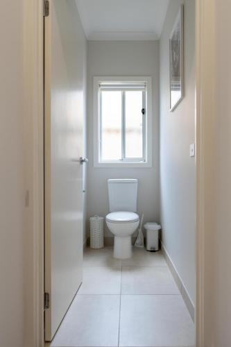a white bathroom with a toilet and a window at Homely Entire house in Clyde in Clyde