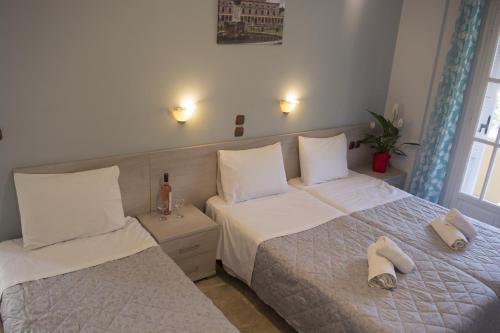 a bedroom with two beds with towels on them at Marina Apartments, Agios Gordios Corfu in Agios Gordios