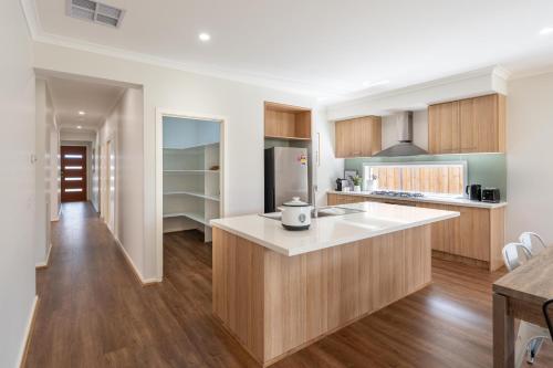 a kitchen with wooden cabinets and a white counter top at Homely Entire house in Clyde in Clyde