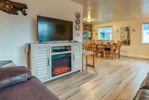 a living room with a fireplace and a tv at The Lighthouse in Lincoln City in Lincoln City