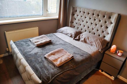 een bed met twee handdoeken in een slaapkamer bij Beautiful 3-bed apartment at Swiss Cottage in Londen