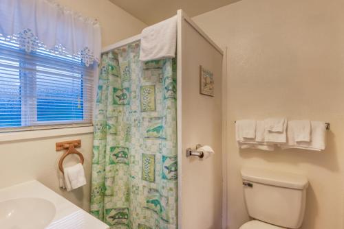 a bathroom with a toilet and a shower curtain at The Lighthouse in Lincoln City in Lincoln City