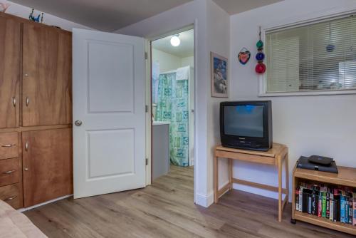 a living room with a tv and a door at The Lighthouse in Lincoln City in Lincoln City