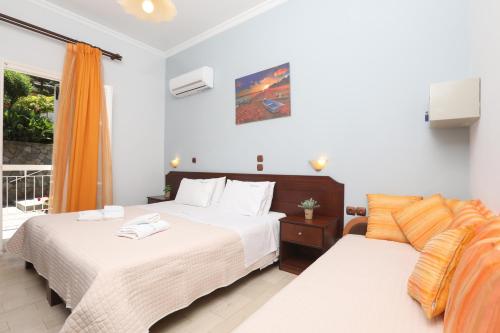 a bedroom with two beds and a window at Marina Apartments, Agios Gordios Corfu in Agios Gordios