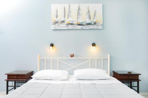 a bedroom with a white bed with two night stands at Marina Apartments, Agios Gordios Corfu in Agios Gordios