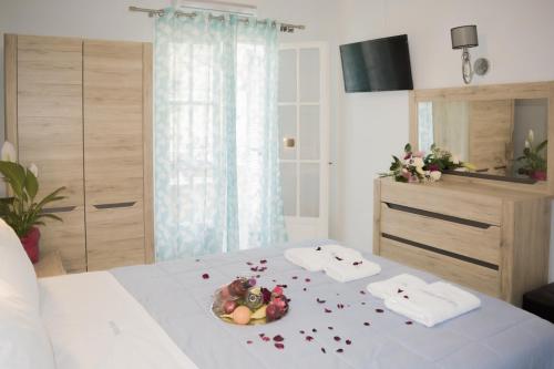 a bedroom with a bed with a bowl of fruit on it at Marina Apartments, Agios Gordios Corfu in Agios Gordios