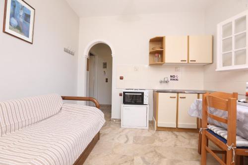 a living room with a couch and a kitchen at Marina Apartments, Agios Gordios Corfu in Agios Gordios
