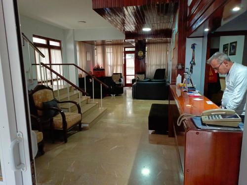 a man standing at a counter in a lobby at Begumhan Pansiyon in Antalya