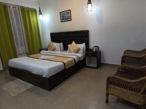 um quarto com uma cama e uma cadeira em Hotel Rainbow em Gangtok