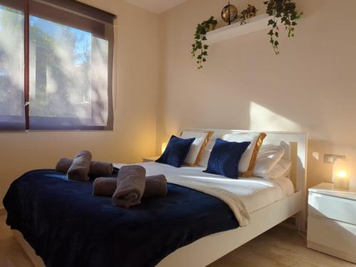 a bedroom with a large bed with blue and white pillows at Frontline 2 bed apartment, San Pedro de Alcántara in Marbella