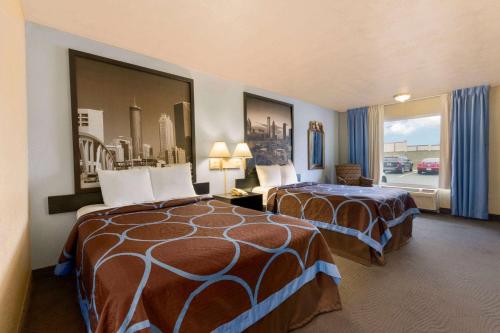 a hotel room with two beds and a window at Super 8 by Wyndham College Park/Atlanta Airport West in Atlanta