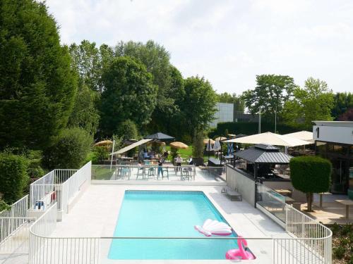 uma piscina com chinelos cor-de-rosa num resort em Novotel Marne La Vallée Collégien em Collégien