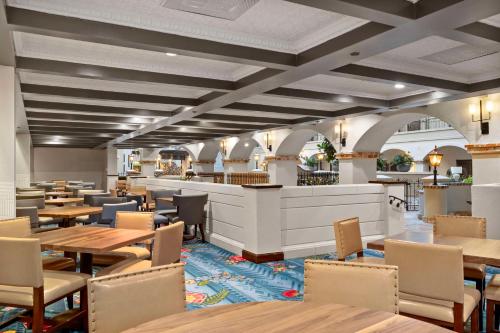a restaurant with tables and chairs and a bar at Embassy Suites by Hilton Los Angeles International Airport South in El Segundo