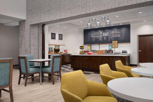 a restaurant with tables and chairs and a counter at Hampton Inn & Suites Orangeburg, SC in Orangeburg