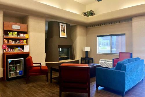 una sala d'attesa con sedie colorate e un camino di Comfort Suites Peoria Sports Complex a Peoria