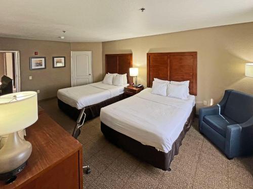 a hotel room with two beds and a blue chair at Comfort Inn & Suites North Glendale and Peoria in Glendale