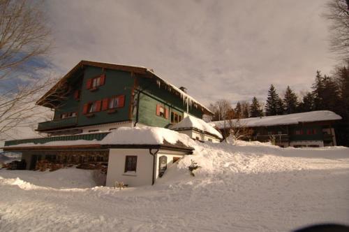 a house covered in snow in a snowy field at Hochberghaus Resort in Grünau im Almtal