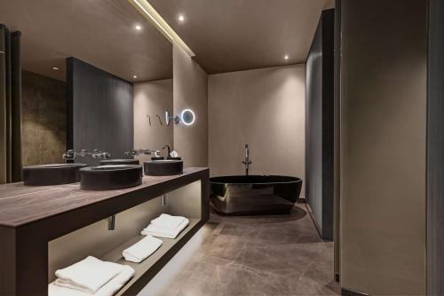 a bathroom with two sinks and a bath tub at Hilton Porto Gaia in Vila Nova de Gaia