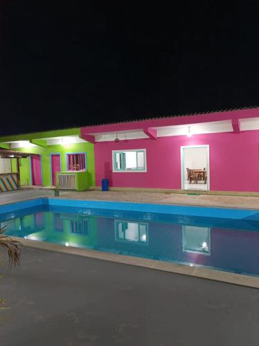 une maison avec une piscine la nuit dans l'établissement Pousada das Ostras, à Anchieta