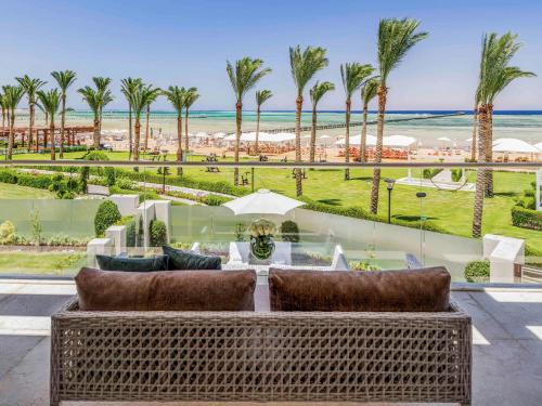 a view of a patio with palm trees and the ocean at Rixos Premium Seagate - Ultra All Inclusive in Sharm El Sheikh