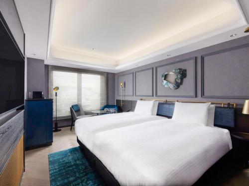 a bedroom with a large white bed and a desk at Mercure Tokyo Haneda Airport in Tokyo