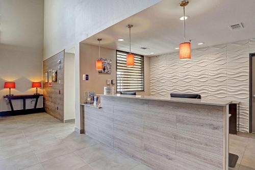 um átrio com um balcão de recepção com luzes laranja em Country Inn & Suites by Radisson Houston Westchase-Westheimer em Houston