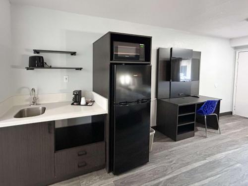 a kitchen with a black refrigerator and a sink at Studio 6 Bakersfield, CA South in Bakersfield