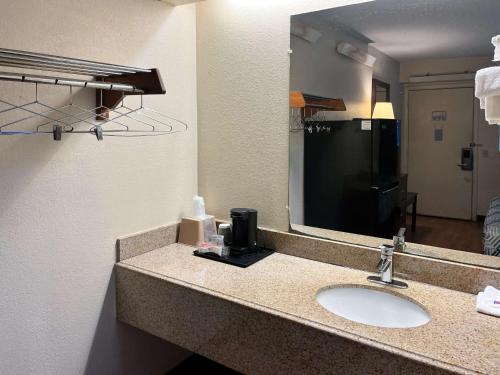 a bathroom with a sink and a large mirror at Studio 6 Suites Shreveport, LA Industrial Loop in Shreveport
