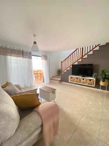 a living room with a couch and a staircase at Meraki in Playa Blanca