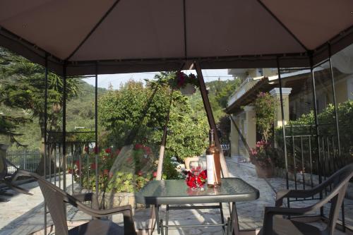 a table and chairs under an umbrella on a patio at Marina Apartments, Agios Gordios Corfu in Agios Gordios