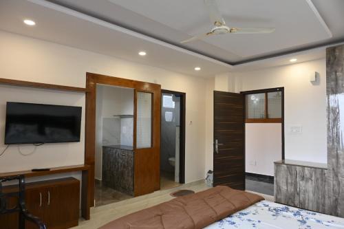 a bedroom with a bed and a flat screen tv at Hazelwood in Kandāghāt