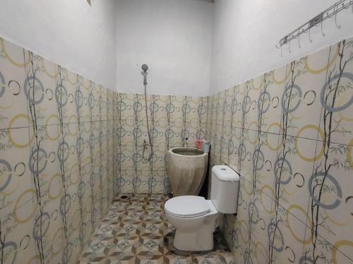 a bathroom with a toilet and a sink at Java Mulia Homestay Syariah in Randusari