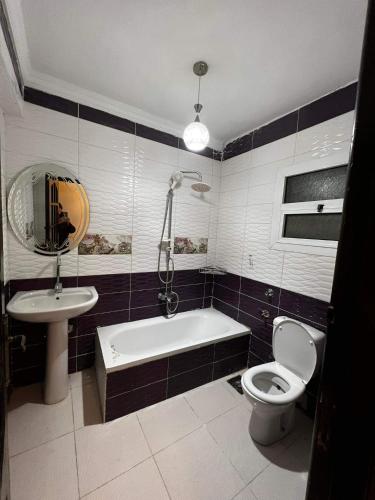 ein Badezimmer mit Badewanne, Toilette und Waschbecken in der Unterkunft Corniche Glimpse in Alexandria