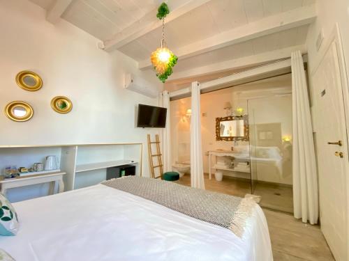 1 dormitorio con 1 cama blanca en una habitación en In centro unique rooms en Olbia