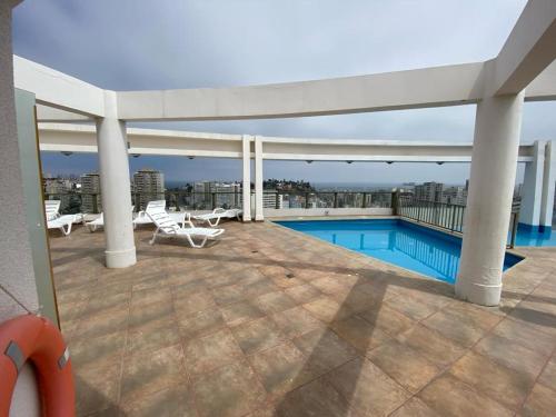 eine Terrasse mit Swimmingpool auf dem Dach eines Gebäudes in der Unterkunft Hermoso y cómodo departamento en el centro de Viña del Mar - Viña Park 2 in Viña del Mar